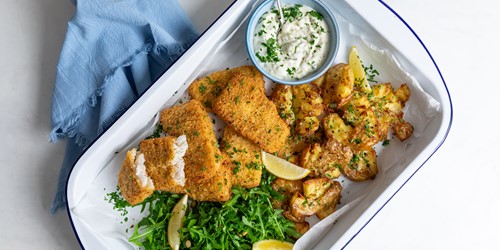 sealords spin on Classic Hoki Fish & Chips serviced on a white dish garnished with herbs, lemon and sauce.