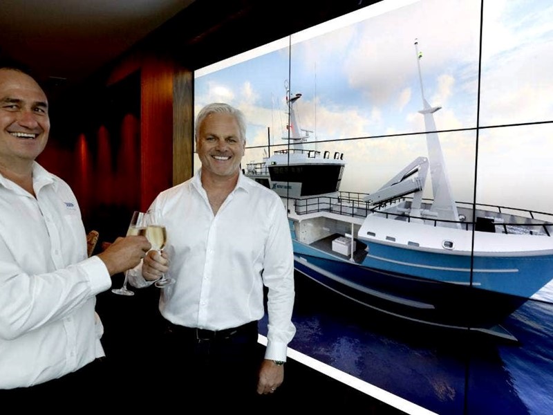 Two Sealord managers toasting with wine glasses in front of a projector screen displaying a new fishing vessel.