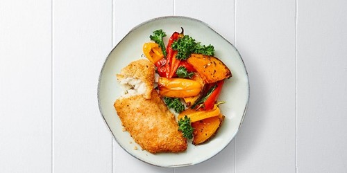 Thai lime and coconut hoki fillet served with colourful roasted vegetables including pumpkin, capsicum, and kale on a ceramic plate.