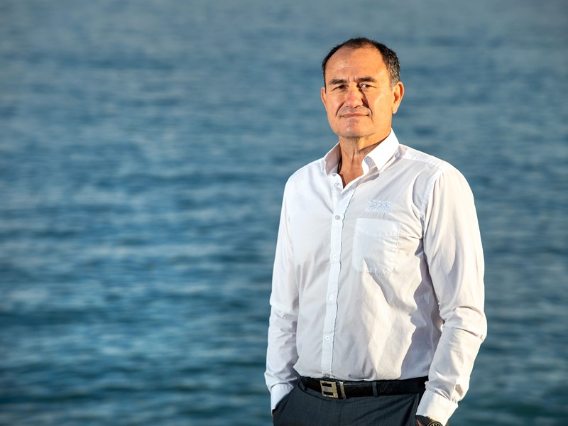 Sealord CEO Doug Paulin standing infront of calm sea, dressed in a button up white shirt and has the sunlight shining on his face