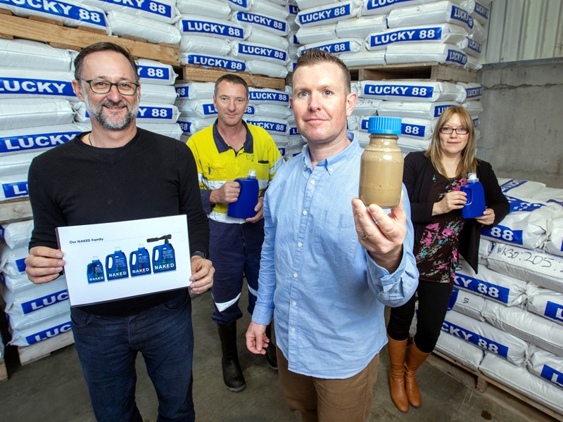 Three men standing and holding new fertiliser that is being launched -by-product of fishmeal.